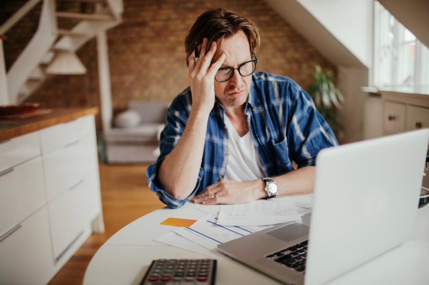 A person at a laptop with a serious expression.