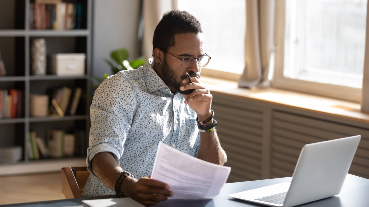 An investor looks pensively at a laptop screen.
